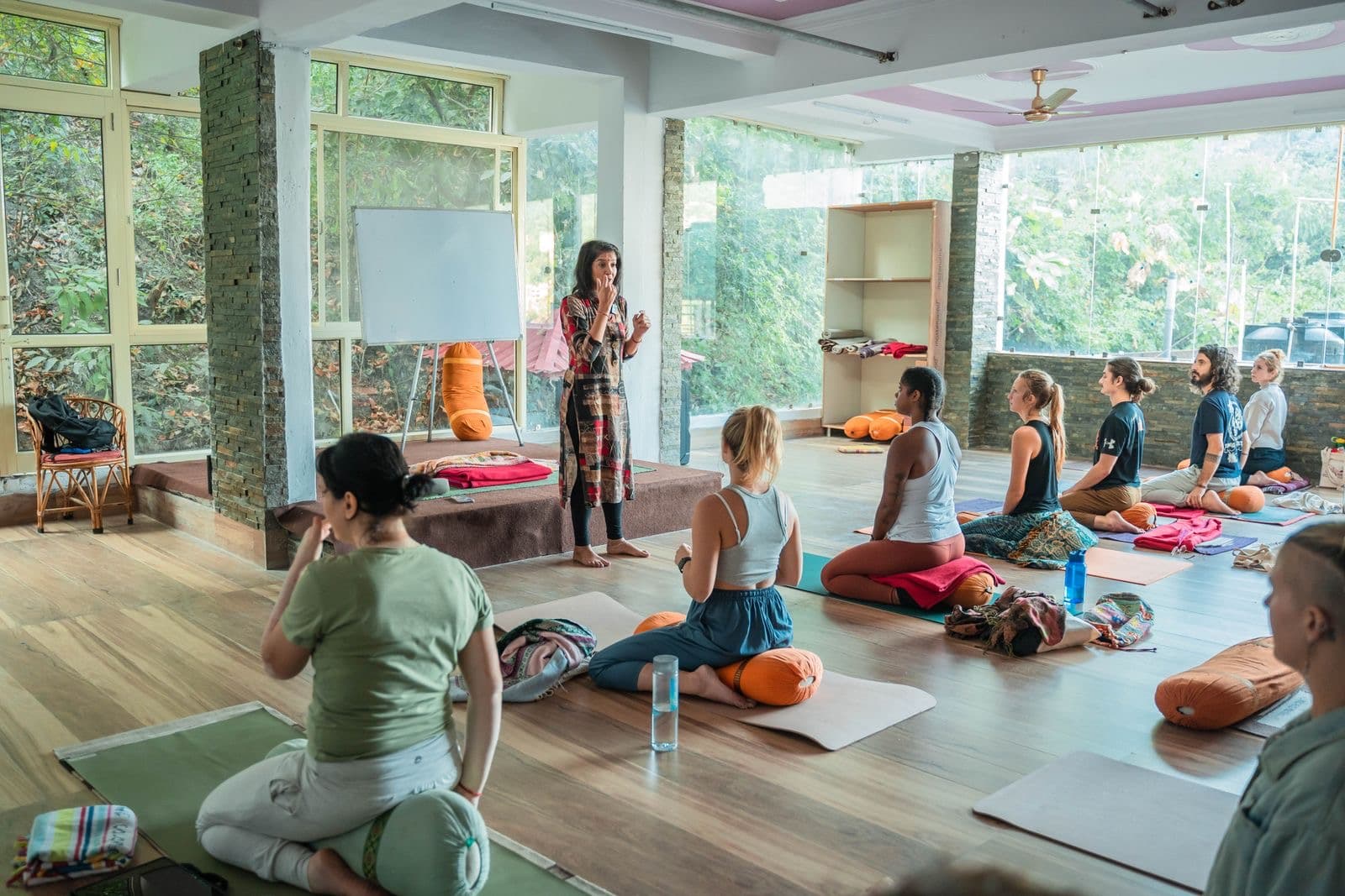 An Ayurveda educator teaching an international cohort of students in a light-filled hall